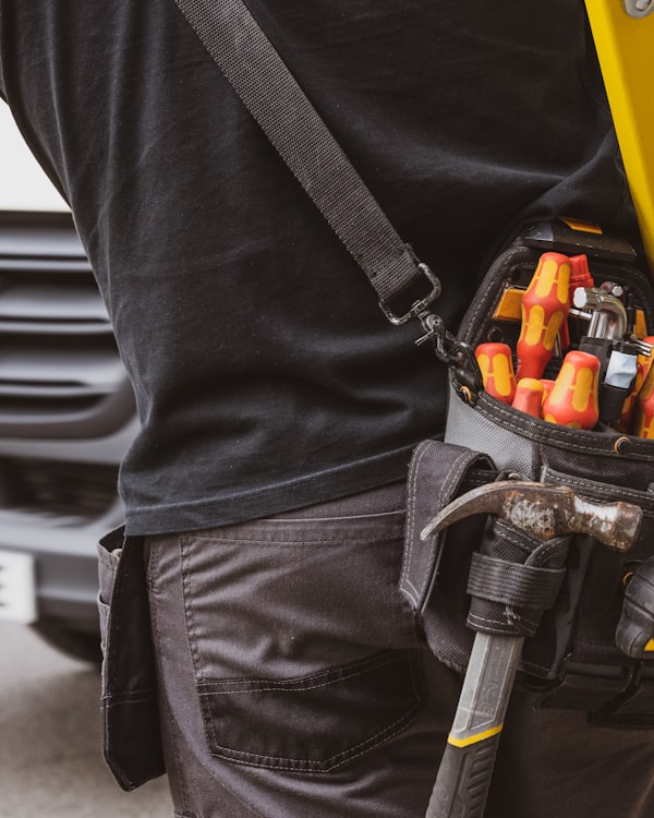 Professional plumber with tool belt ready for service
